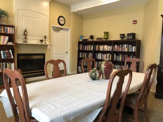 Common area with bookshelves and a dining table