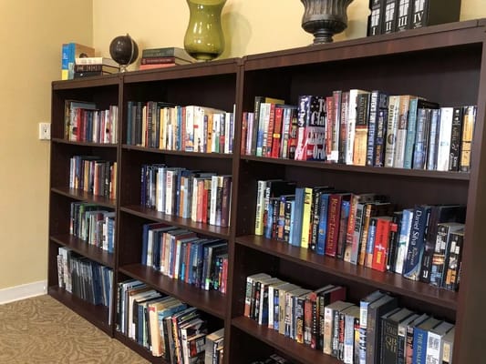 Bookshelves filled with various books in a common area