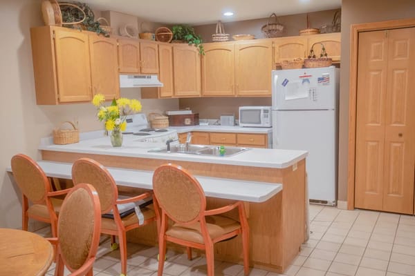 Bright kitchen area with seating and flowers
