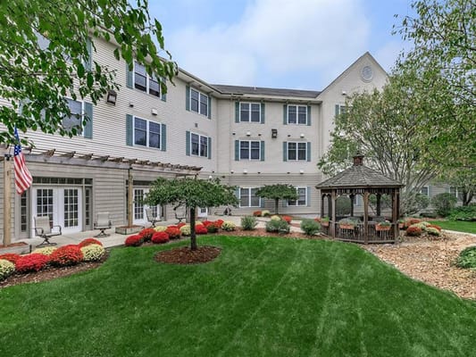 Lush garden area with gazebo and colorful flowers outside The Meetinghouse at Riverfront.