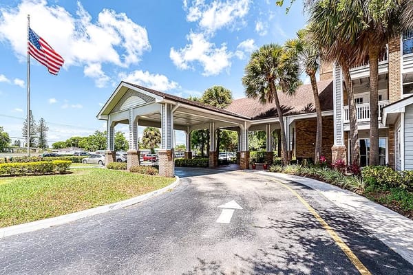 Entrance covered drive with American flag and palm trees
