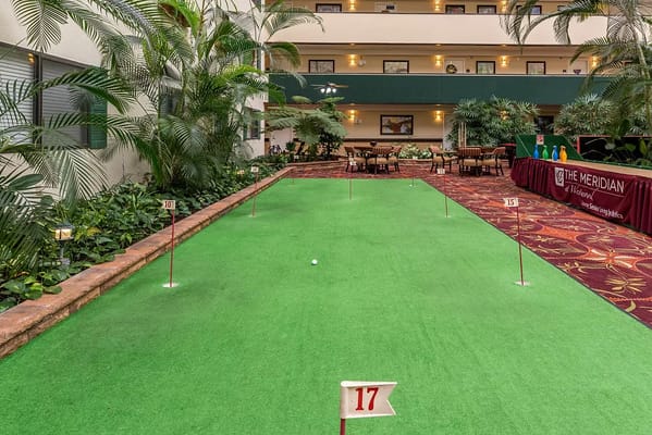 Indoor putting green area with seating nearby