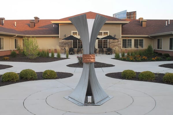 Outdoor courtyard featuring a modern sculpture and seating area