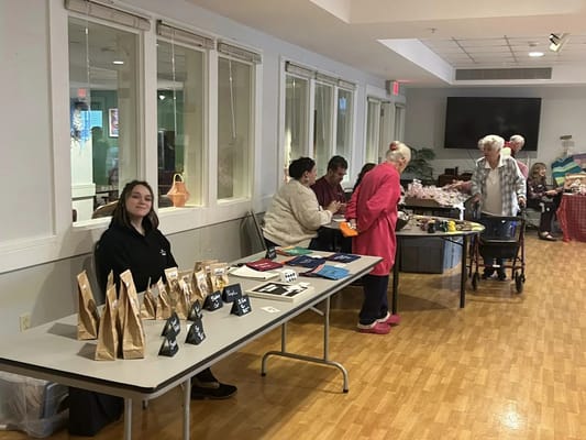 A resident gathering during an activity fair with tables and crafts