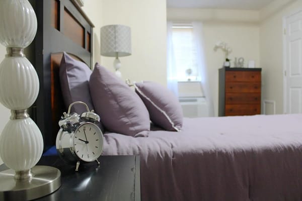 A cozy bedroom setup with a clock and lamp