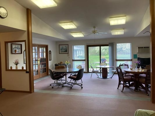 Bright common area with tables and views of the garden