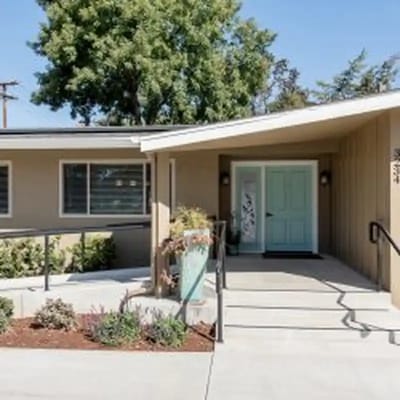 Front entrance with a light blue door and landscaped pathway