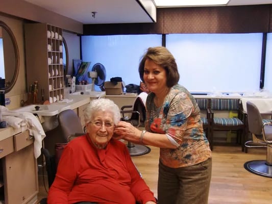 Resident receiving a haircut in the salon area