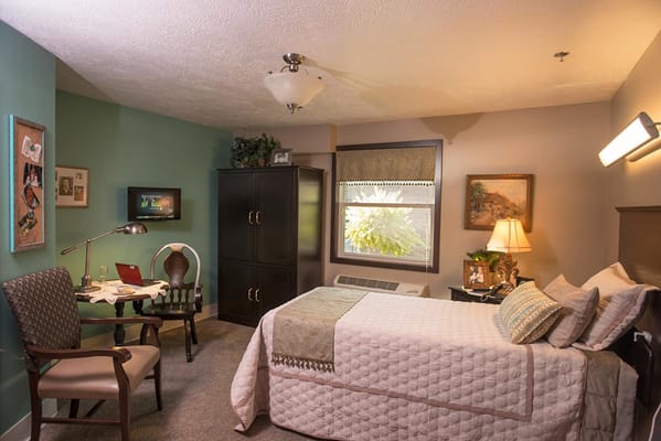 A well-furnished single bedroom in a senior living facility.