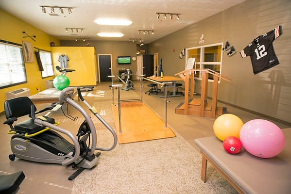 Interior of a therapy room with exercise equipment and therapy balls.