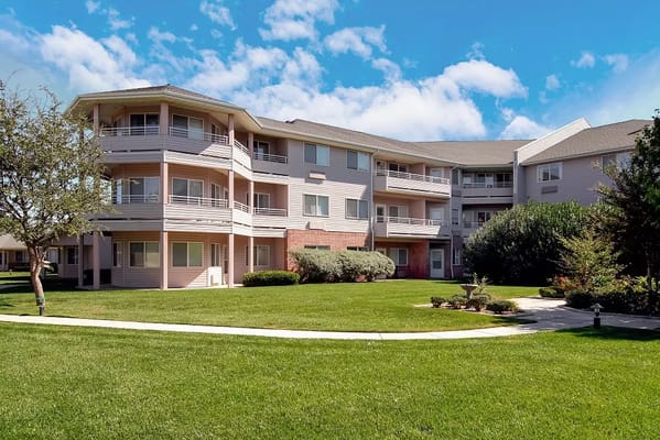 Exterior of Polo Park Estates surrounded by green lawn and trees