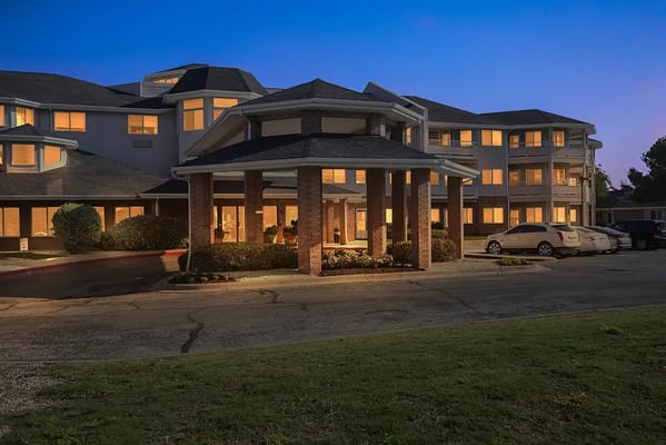 Exterior of Polo Park Estates at dusk, showcasing the entrance and landscaping.