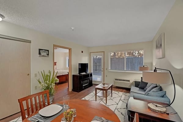 Cozy living room with dining table and TV in senior living facility