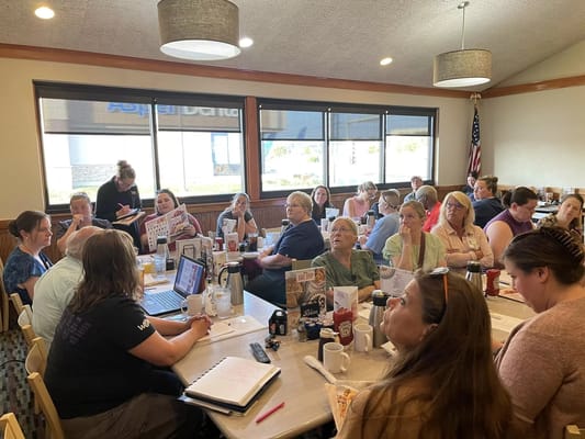 Staff meeting with many participants in a cozy setting.
