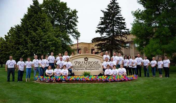 Staff members posing in front of the facility sign