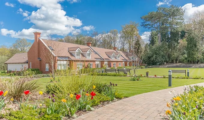Exterior view of a senior living facility with a garden