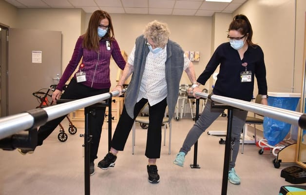 Therapist assisting a resident with rehabilitation exercises