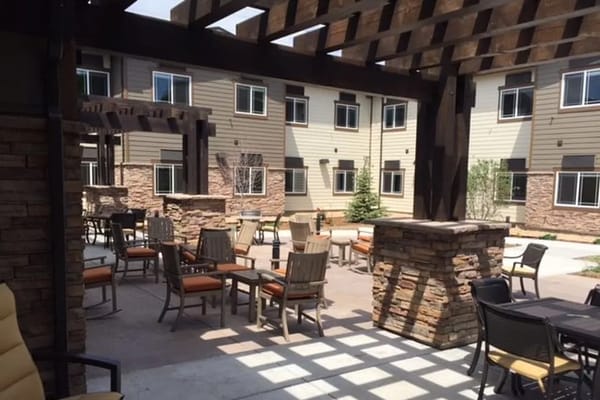 Outdoor seating area with tables and chairs in a sunny courtyard