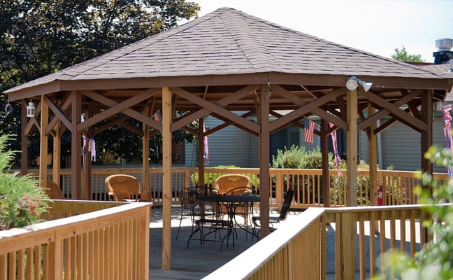 Wooden gazebo with seating area and decorative flags