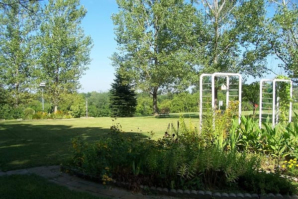 Vibrant garden with trees and flower beds in Risen Son Christian Village