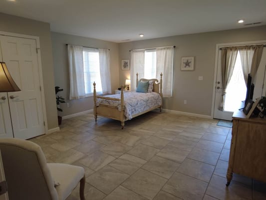 Brightly lit interior of a bedroom with a bed and chair