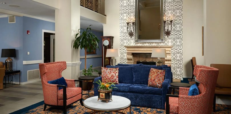 Inviting living room with blue couch and colorful armchairs.