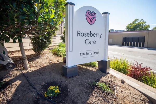Sign for Roseberry Care near a garden