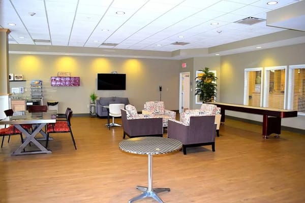A spacious common area with seating and a dining area at Sanctuary Grande.