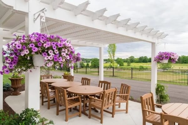 Wooden tables and hanging flower pots in outdoor seating area