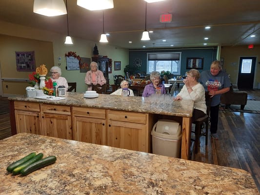 Residents socializing at the kitchen counter in Silver Springs Assisted Living.