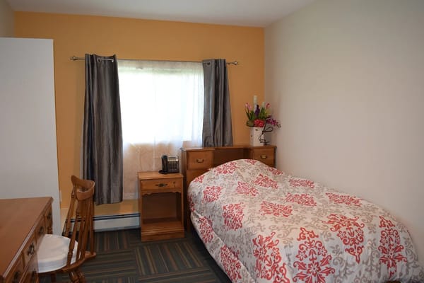 Cozy resident room with floral bedspread and natural light