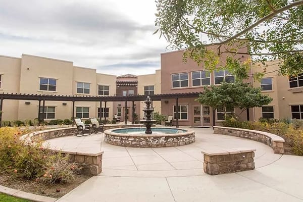 Courtyard featuring a fountain surrounded by seating and gardens