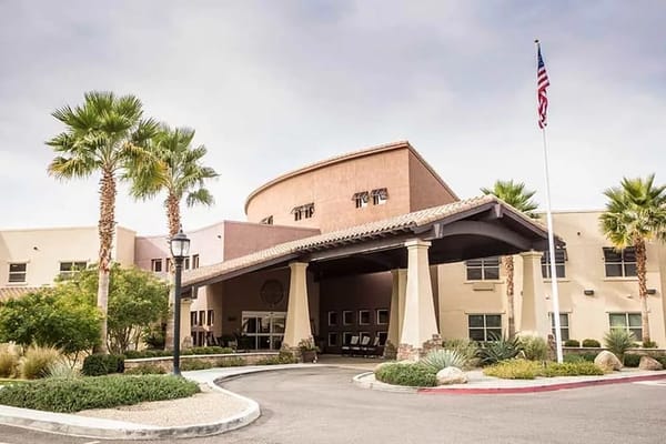 Front entrance of Solana at the Park with palm trees and American flag