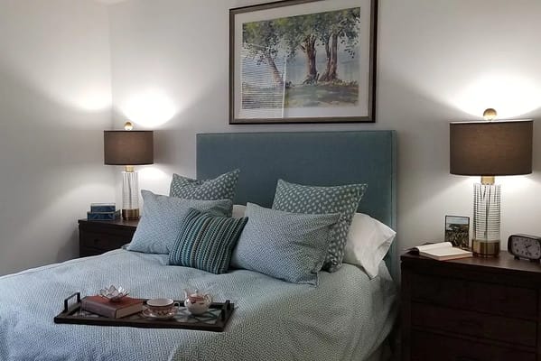 Well-decorated bedroom with a bed, pillows, and bedside lamps