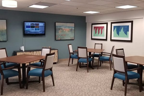 Common area with tables and television at Solstice Senior Living.