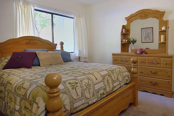 Cozy bedroom with wooden furniture and a floral bedspread