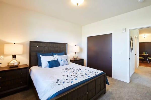 A beautifully decorated bedroom with a bed, nightstands, and lamps.