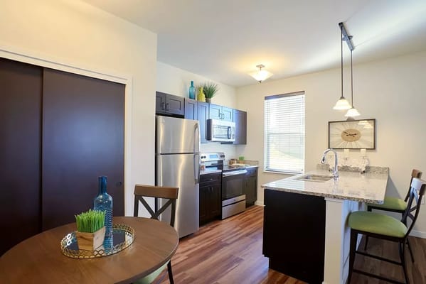 A modern kitchen with stainless steel appliances and granite countertops.