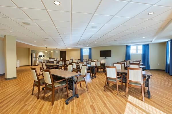 Brightly lit dining room with tables and chairs
