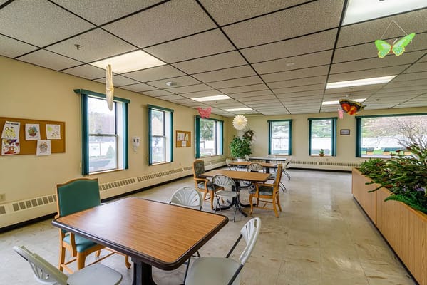 Bright dining area with tables and chairs at St. Vincent De Paul Nursing Home.