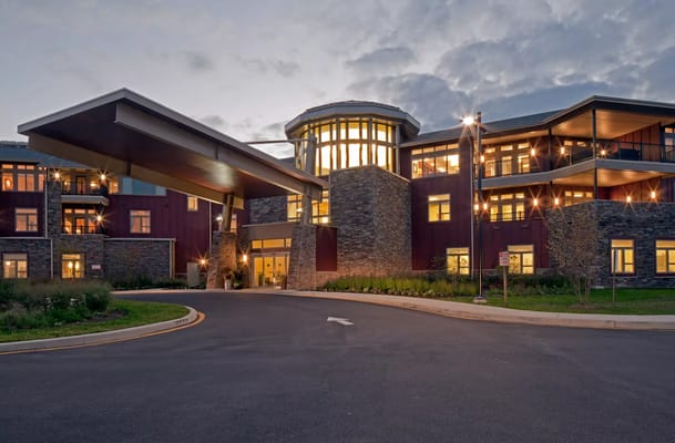 Modern entrance of The Summit senior living facility at dusk