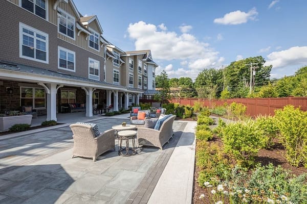 Cozy outdoor lounge area with seating and garden at Sunrise of Wilton
