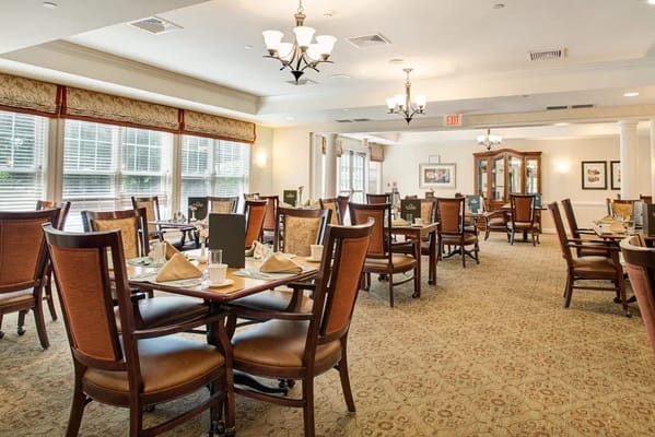 Well-lit dining room with tables set for meals.