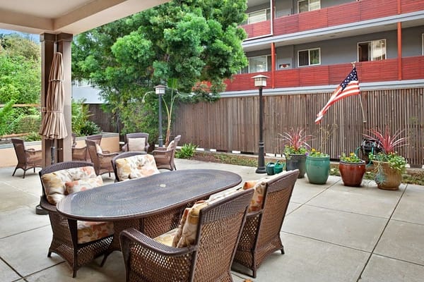 Comfortable outdoor seating area with a dining table and greenery