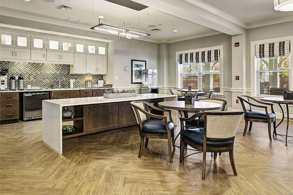 Modern kitchen and dining area with wooden tables and chairs.