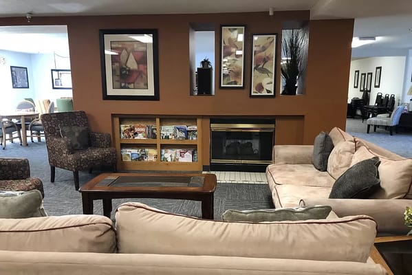 Comfortable living room with couches, armchairs, and a fireplace.