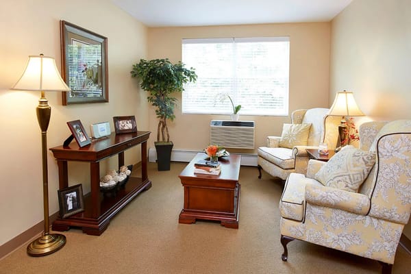 A cozy living room with two armchairs, a coffee table, and a decorative lamp.