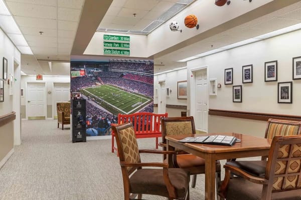 Seating area with a sports-themed mural and directional signs.