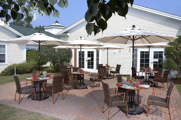 Patio dining setup with umbrellas and tables at The Atrium at Rocky Hill
