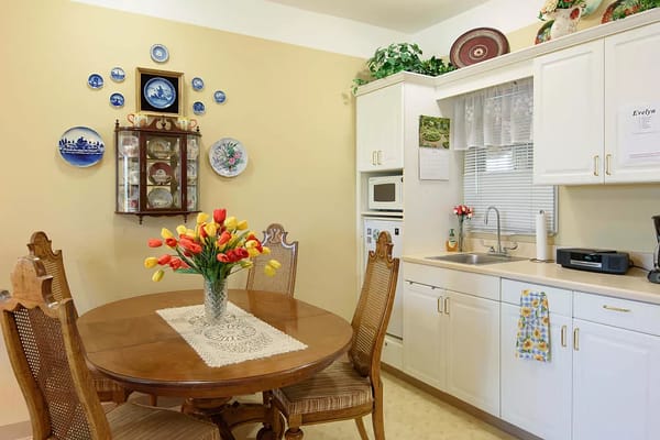 Bright kitchen area with a dining table and flowers